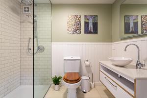 a bathroom with a toilet and a sink and a shower at Stunning Self-contained Apartment in Auckland +20 photos