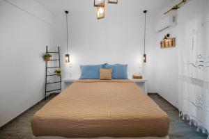 a bedroom with a large bed with blue pillows at Dorkas Luxury Rooms&Apartments in Livadakia