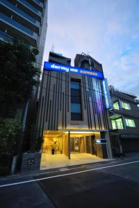een gebouw met een blauw bord erop bij Dormy Inn Express Meguro Aobadai Hot Spring in Tokyo