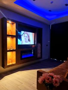 列日Aslyra "Appart-hôtel"的配有电视和鲜花桌的客房