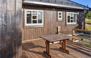 una terraza de madera con un banco y un edificio en Stunning Home In Øyer With Wifi, en Øyer