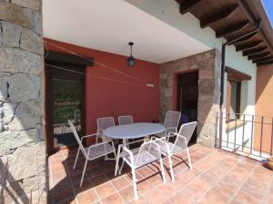 a patio with a table and chairs on a balcony at Casa La Peguera in La Parra