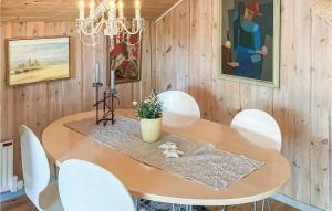 a dining room with a wooden table and white chairs at Lovely Home In Heberg With Sauna in Heberg
