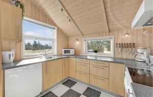 a kitchen with wooden cabinets and a large window at Amazing Home In Skjern With Kitchen in Halby