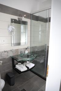 a bathroom with a glass sink and a shower at Stani i Hoxhes Hotel in Kukës