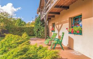 un patio con 2 sillas verdes y una ventana en Holiday Home Rowy Ul Bukowa, en Rowy