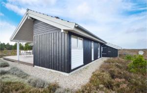 a small house with a black and white exterior at Holiday Home Godthåbsvej Rømø Vi in Bolilmark +20 photos