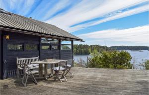 a cabin with a table and chairs on a wooden deck at Four-Bedroom Holiday Home In Tvedestrand in Tvedestrand