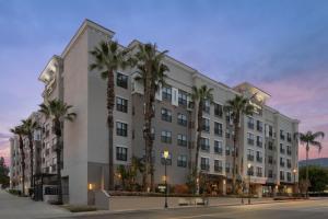 a building with palm trees in front of a street at Residence Inn Los Angeles Burbank/Downtown in Burbank