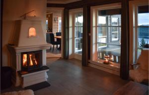 a living room with a fireplace and a dining room at Lovely Home In Hjartdal With Sauna in Hjartdal