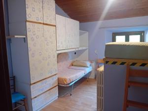 Cette petite chambre comprend des lits superposés et un canapé. dans l'établissement La casa di Bobo, à Pian degli Ontani