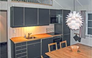 a kitchen with a sink and a table and a chandelier at Holiday Home Gålå Peer Gyntlia Iv in Gålå