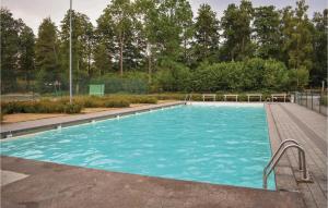 a large swimming pool with blue water at Lovely Home In Hjärnarp With Sauna in Hjärnarp +8 photos