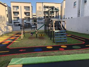 un parque infantil con columpio en un edificio en Exquisite Home In Sandton with Pool and Inverter, en Johannesburgo