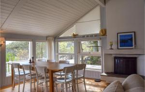 a dining room with a table and chairs and a fireplace at Three-Bedroom Holiday Home In Tvedestrand in Tvedestrand