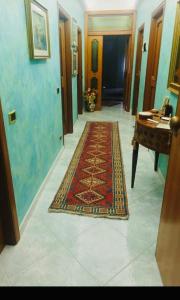 a hallway with a rug on the floor and a piano at La casa di nonna Lia in Tollo