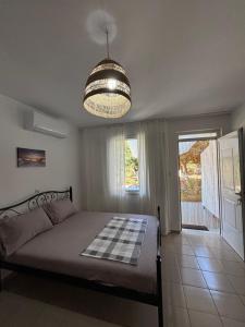 a bedroom with a bed and a chandelier at Cheap holiday rooms in Himare