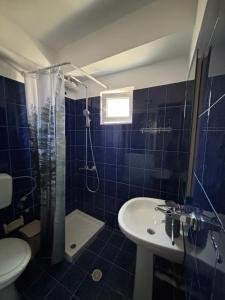 a bathroom with a sink and a shower and a toilet at Cheap holiday rooms in Himare