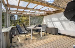 eine Terrasse mit Tisch und Stühlen auf einem Deck in der Unterkunft Holiday Home Moritzvej Rømø Xii in Toftum