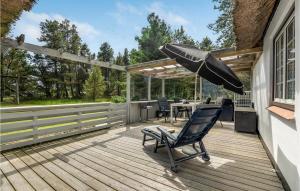 eine Terrasse mit einem Sonnenschirm und einem Stuhl auf einer Terrasse in der Unterkunft Holiday Home Moritzvej Rømø Xii in Toftum