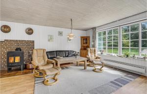 ein Wohnzimmer mit Tisch und Stühlen und einem Kamin in der Unterkunft Holiday Home Moritzvej Rømø Xii in Toftum