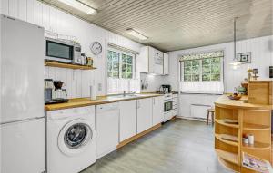 eine Küche mit weißen Schränken und einer Waschmaschine und einem Trockner in der Unterkunft Holiday Home Moritzvej Rømø Xii in Toftum + 18 Fotos