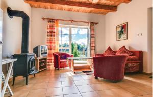 ein Wohnzimmer mit einem Holzofen und roten Stühlen in der Unterkunft 1 Bedroom Beautiful Apartment In Rowy in Rowy
