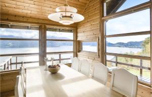 a dining room with a table and chairs and windows at Gorgeous Home In Norheimsund With Wifi in Norheimsund