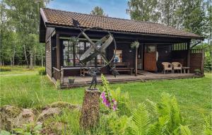 a small house with a large windmill in the yard at Nice Home In Timmele With Sauna in Timmele