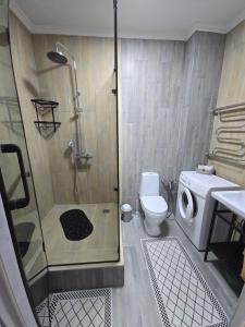 Un baño con ducha, inodoro y lavabo. en Алматушечка, en Almaty 36 fotos más