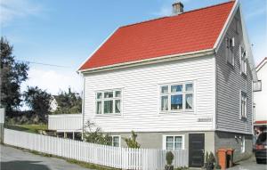 a white house with a red roof and a white fence at Holiday Home Skudeneshavn Kvednadalen in Skudeneshavn