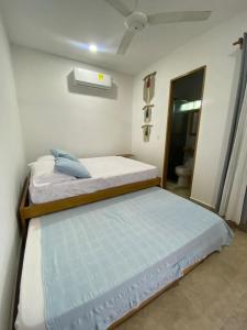 a small bedroom with two beds and a bathroom at Small Home Arboletes in Arboletes