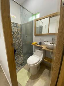 a bathroom with a toilet and a sink and a shower at Small Home Arboletes in Arboletes +7 photos