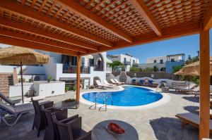 
a patio area with chairs, tables, and a pool at Orama Apartments in Agia Anna Naxos
