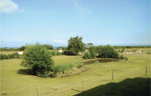 a field with a fence and some animals in it at Amazing Apartment In Börgerende in Börgerende-Rethwisch