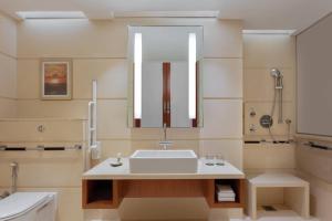 a bathroom with a sink and a mirror at Courtyard by Marriott Kochi Airport in Nedumbassery
