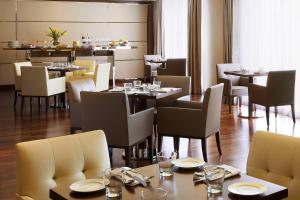 a dining room with tables and chairs in a restaurant at Courtyard by Marriott Kochi Airport in Nedumbassery