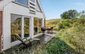 a patio of a house with a bench and a table at Holiday Home Nørre Nebel 10 in Nymindegab