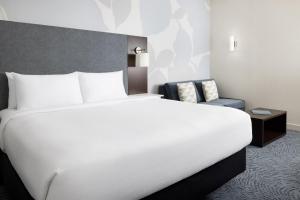 a bedroom with a large white bed and a chair at Residence Inn by Marriott New York Downtown Manhattan/World Trade Center Area in New York