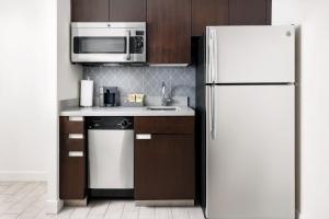 a kitchen with a white refrigerator and a microwave at Residence Inn by Marriott New York Downtown Manhattan/World Trade Center Area in New York