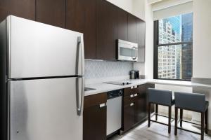 a kitchen with a refrigerator and two chairs at Residence Inn by Marriott New York Downtown Manhattan/World Trade Center Area in New York