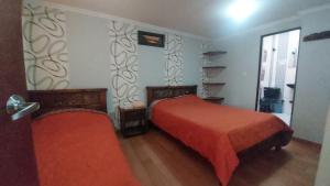 a bedroom with two beds and a window at Hotel Posada San Laureano in Tunja