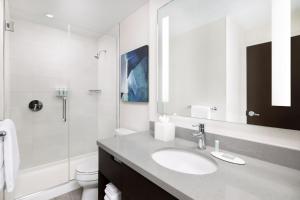 a white bathroom with a sink and a shower at Residence Inn by Marriott New York Downtown Manhattan/World Trade Center Area in New York