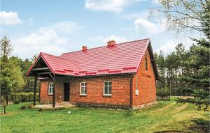 a small brick house with a red roof at Holiday Home Cekcyn Ul Lesna in Cekcyn