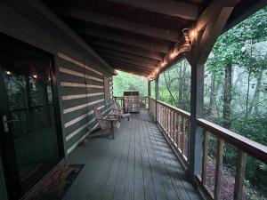 a porch of a house with chairs on it at Treetop Cabin in Cedar Mountain