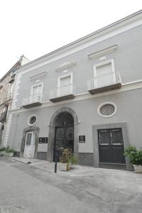 a large white building with a door and a balcony at Stone House Michelle in Torre Annunziata