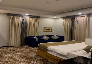 a bedroom with two beds and a blue couch at فندق البيوتات in Jeddah +73 photos