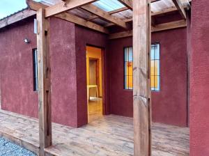 an open door of a house with a wooden porch at Chalet Volga - Punta Del Diablo - Departamento de Rocha in Punta Del Diablo