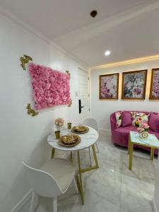 a living room with a table and a pink couch at MAKATI Isabela Luxury in Manila