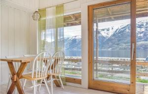 a dining room with a table and chairs and a window at 2 Bedroom Cozy Home In Vallavik in Bu